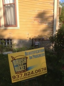 The Brush and Bucket- sign with a house getting a proper prep job